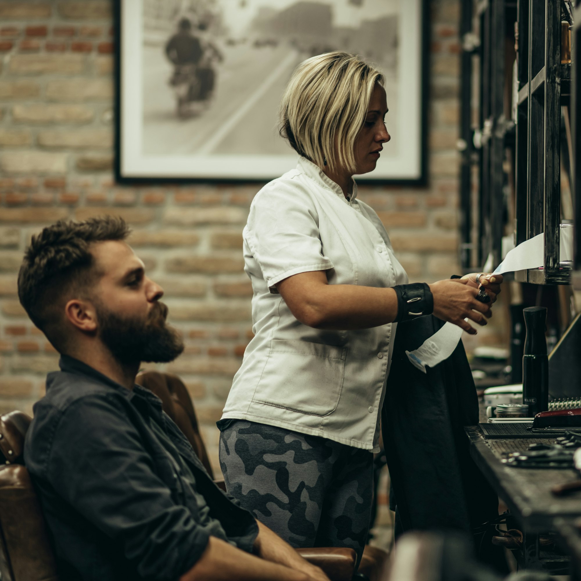 man-getting-talking-with-his-hairdresser-while-sitting-in-chair-at-barbershop.jpg