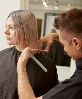male-hairdresser-cutting-woman-hair-in-beauty-salon.jpg