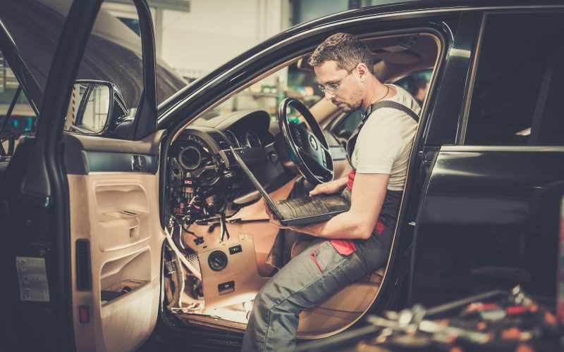 serviceman-making-car-diagnostics-with-laptop-in-a-workshop.jpg